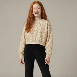 Dziewczynka w beżowym swetrze i czarnych spodniach na jasnym tle. Dziewczynka w beżowym swetrze i czarnych spodniach na jasnym tle.