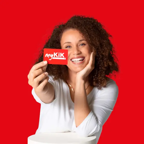 myKiK Osoba z kręconymi włosami trzyma czerwoną kartę myKik na czerwonym tle.
